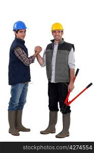 Two manual workers shaking hands