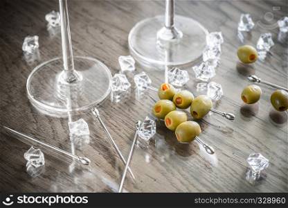 Two martini glasses with olives on martini picks