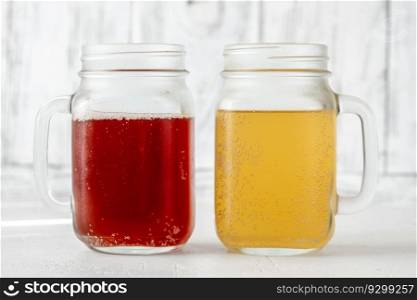 Two Mason jars with various kombucha drinks