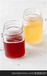 Two Mason jars with various kombucha drinks