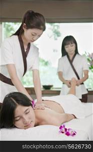 Two Masseuses Massaging One Woman