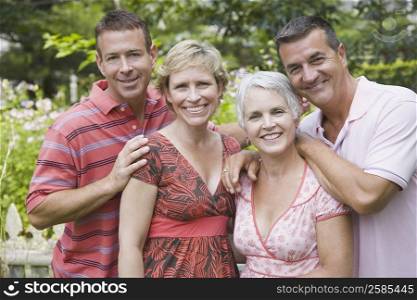 Two mature couples smiling in a park