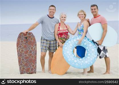 Two mature couples standing on the beach
