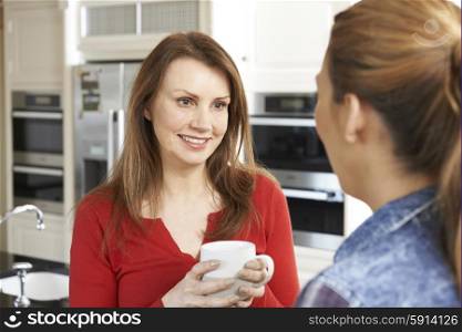 Two Mature Female Friends Talking In Kitchen Together