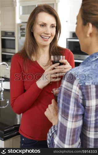 Two Mature Female Friends Talking In Kitchen Together
