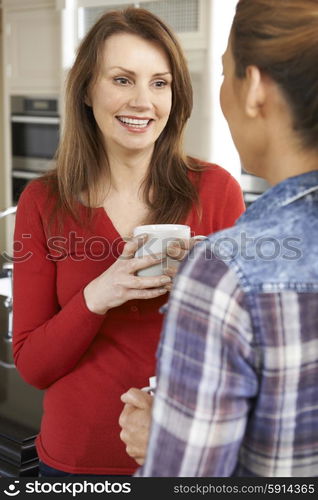 Two Mature Female Friends Talking In Kitchen Together