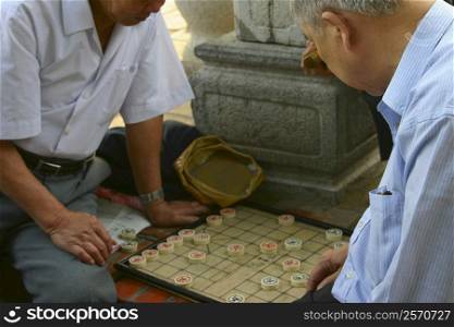 Two mature men playing a board game, Hanoi, Vietnam