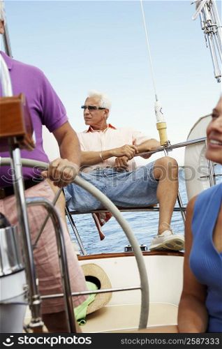 Two mature men with a mature woman traveling in a boat
