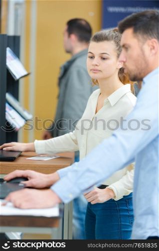 two mature students working together using laptop