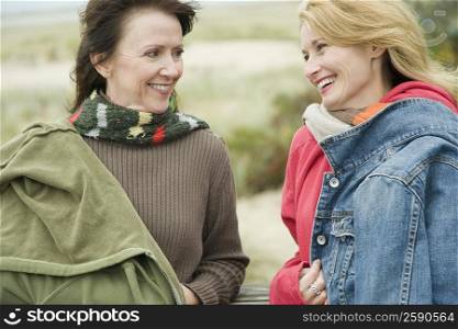 Two mature women gossiping and smiling