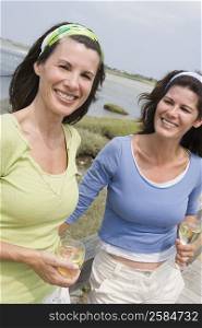 Two mature women holding glasses of wine and smiling