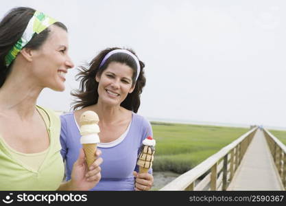 Two mature women holding ice cream cones and smiling