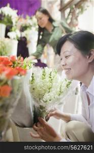 Two Mature women Looking At Flowers In Flower Shop