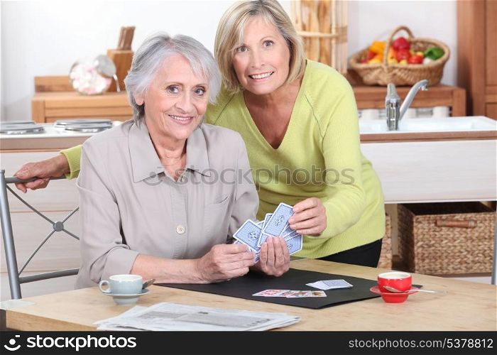 Two mature women playing cards.