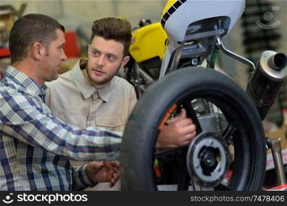 two mechanics in a motorbike garage