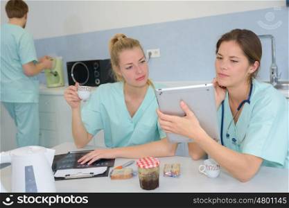two medical coworkers looking at a tablet