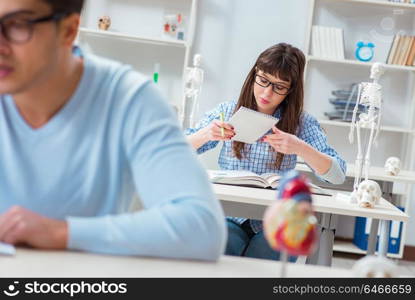 Two medical students studying in classroom