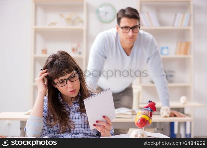 Two medical students studying in classroom