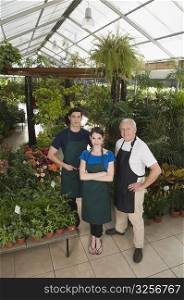 Two men and a woman standing together in a garden center