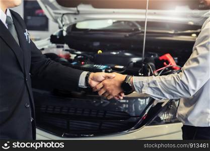 Two men Asian holding hands or shake hands to mechanic with boss manager service inspection.for service maintenance of industrial to engine repair.In Factory transport automobile automotive image