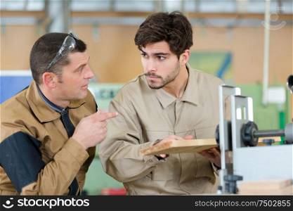 two men assembling product in carpentry workshop