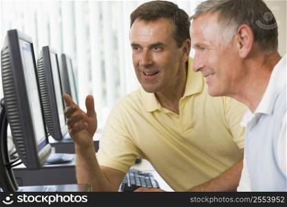 Two men at a computer terminal talking (depth of field/high key)