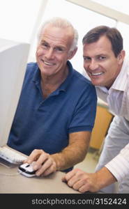 Two men at computer smiling (high key)