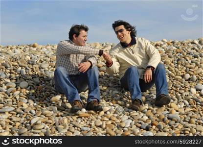 two men at the beach, in a handshake