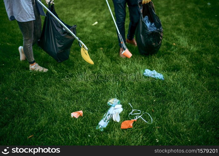 Two men collects plastic garbage in bags in park, volunteering. Male person cleans forest, ecological restoration, eco lifestyle, trash collection and recycling, ecology care, cleaning. Two men collects plastic garbage, volunteering