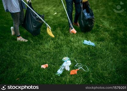 Two men collects plastic garbage in bags in park, volunteering. Male person cleans forest, ecological restoration, eco lifestyle, trash collection and recycling, ecology care, cleaning. Two men collects plastic garbage, volunteering