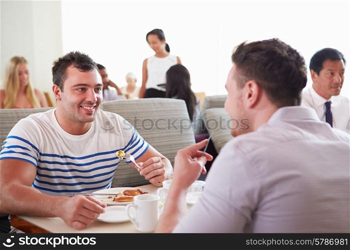 Two Men Enjoying Breakfast In Hotel Restaurant