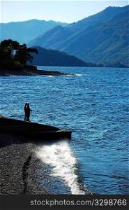 Two men fishing on a italian lake dock