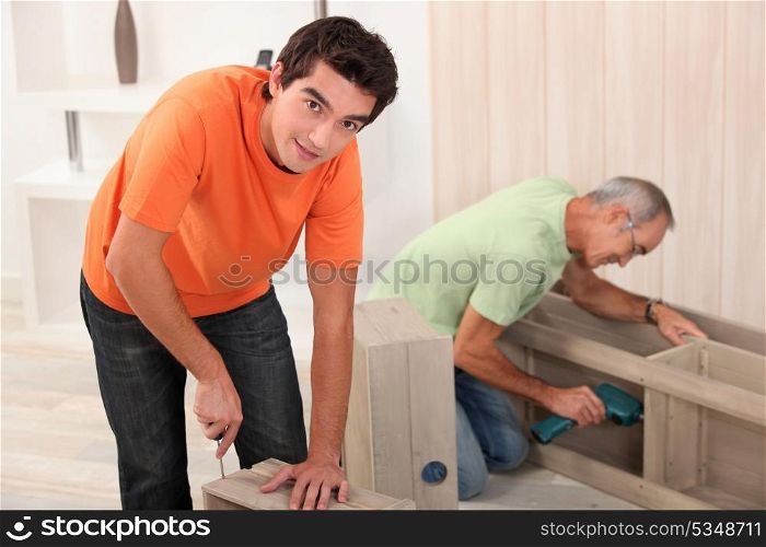 two men fixing furniture