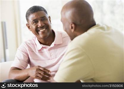 Two men in living room talking and smiling