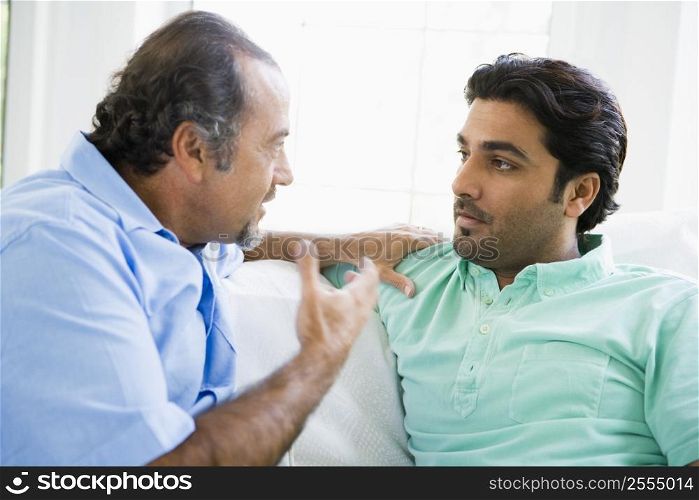 Two men in living room talking (high key)