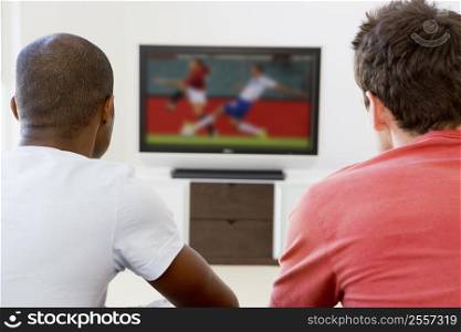Two men in living room watching television