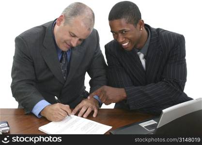 Two men in suits at desk signing papers.