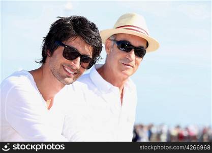 Two men in white tops and sunglasses