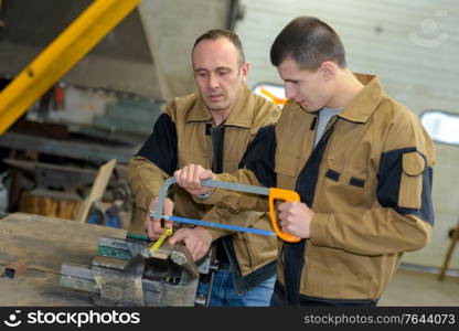 two men in workwear in a carpenters workshop