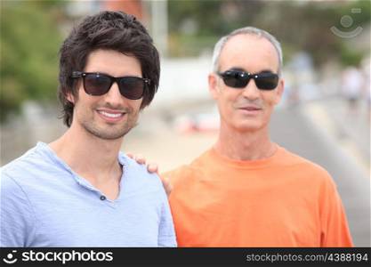 Two men of different generations wearing sunglasses and t-shirts