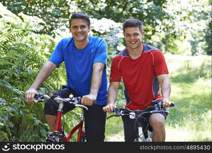 Two Men On Cycle Ride In Countryside Together