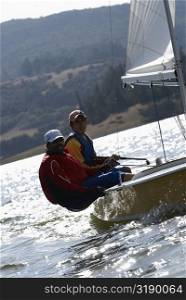 Two men participating in a sailboat race