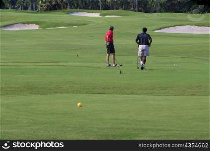 Two men playing golf in a golf course