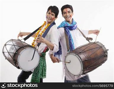 Two men playing on dholaks