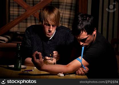 Two men preparing heroin