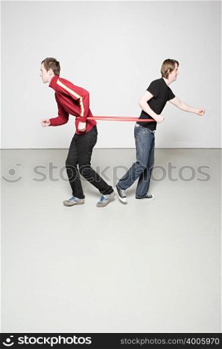 Two men pulling plastic hoop