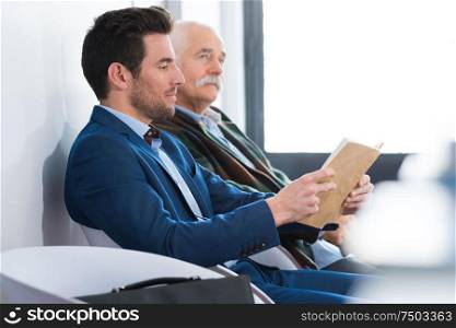 two men reading in wating room