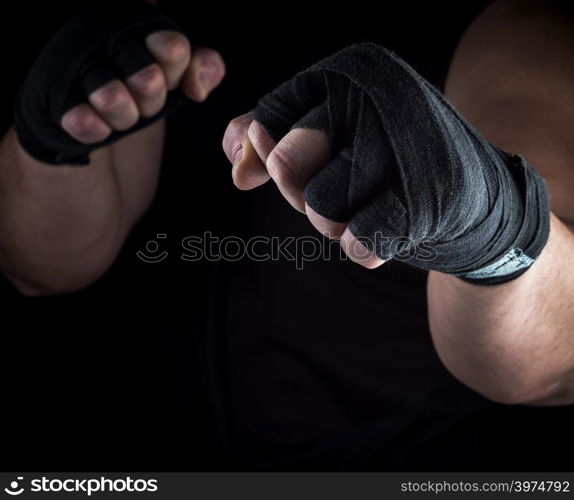 two men&rsquo;s hands rewound with a black textile band, stand for attack and defense