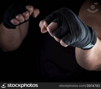 two men&rsquo;s hands rewound with a black textile band, stand for attack and defense
