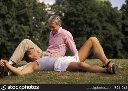 Two men sitting on grass